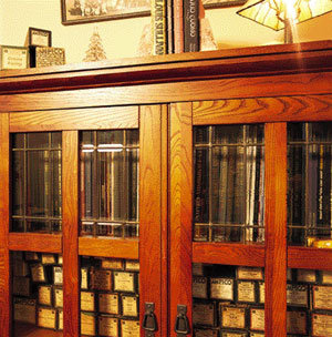 Player piano scrolls, as well as art and music books, are tucked into this oak cabinet in the dining room.